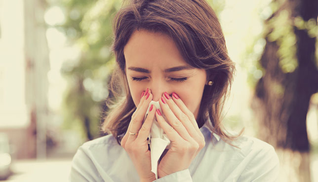 Mujer con un pañuelo en la nariz - Infecciones respiratorias