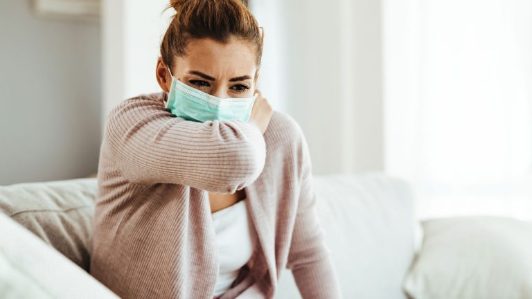 Mujer con tapabocas, tosiendo - Tuberculosis