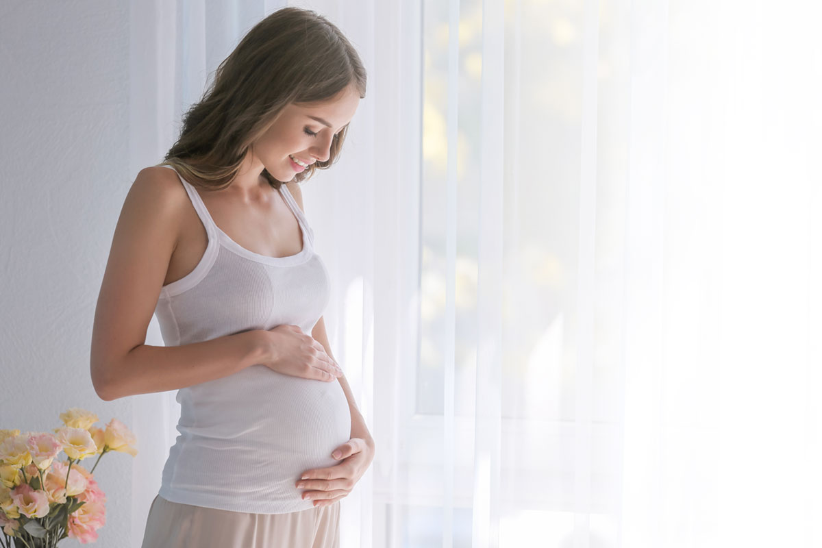 Mujer embarazada de unos meses, acariciando su barriga - Test pre natal no invasivo