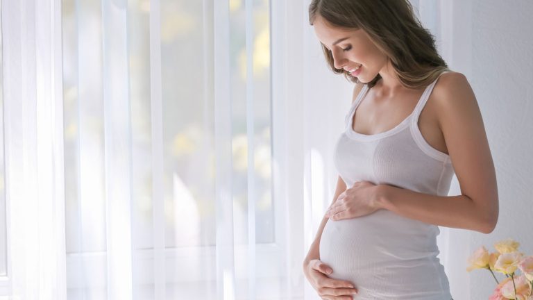 Mujer embarazada de unos meses, acariciando su barriga - Test pre natal no invasivo